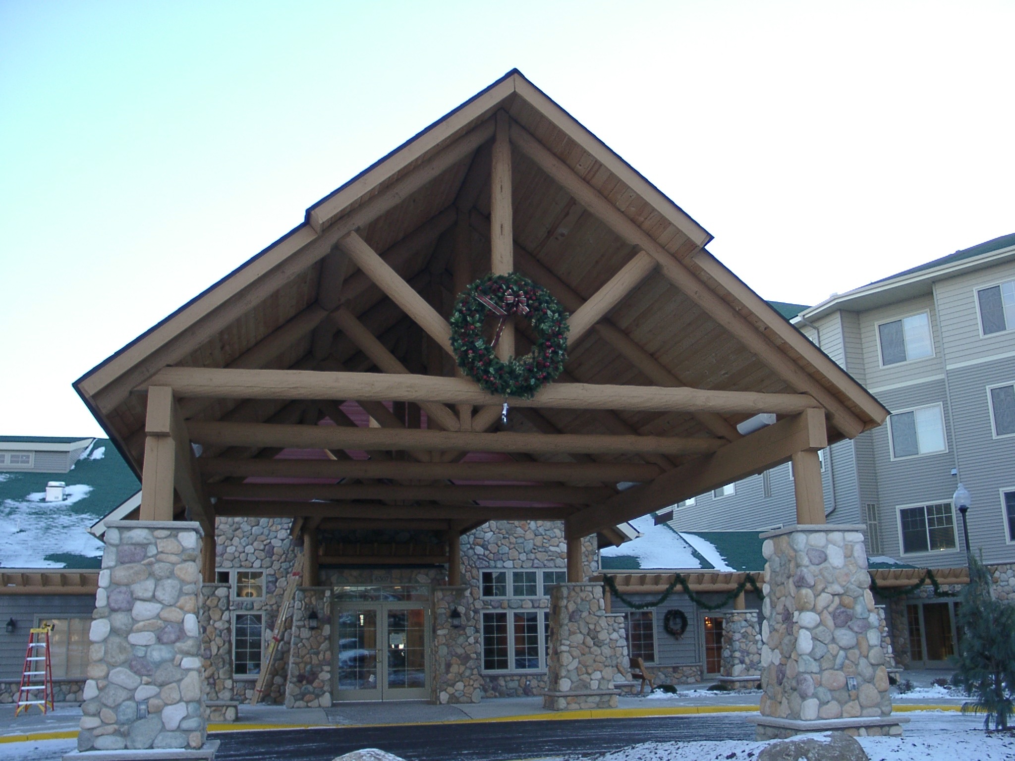Custom wood and stone parking lot entrance arch awning
