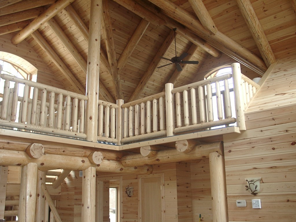 Wooden building interior with custom log accent support beams and railings | Wood Stair Railings