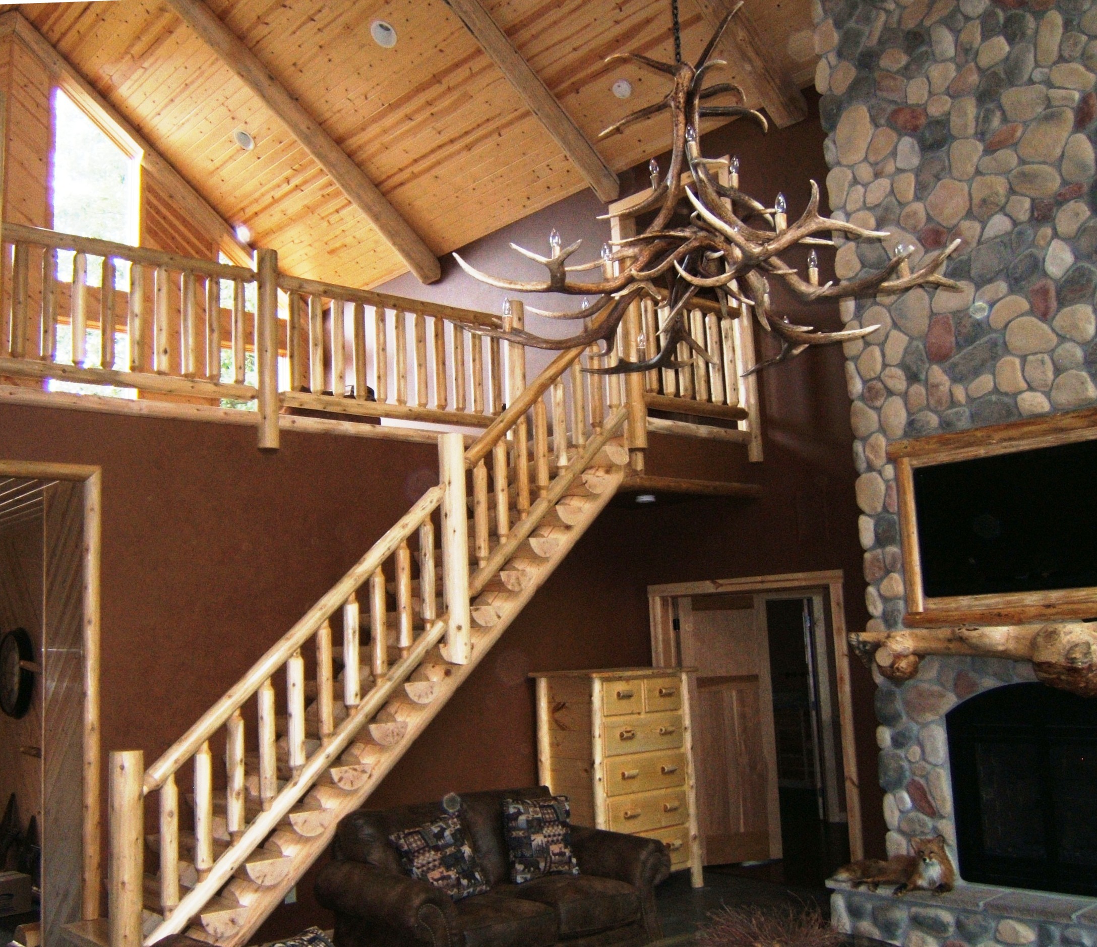 rustic cabin interior with natural timber staircase and antler chandelier | Wood Stair Railings